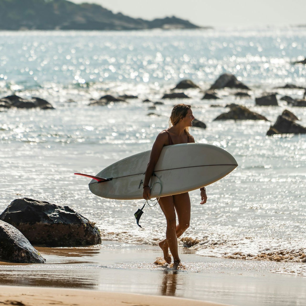Woman holding surfboard on beach