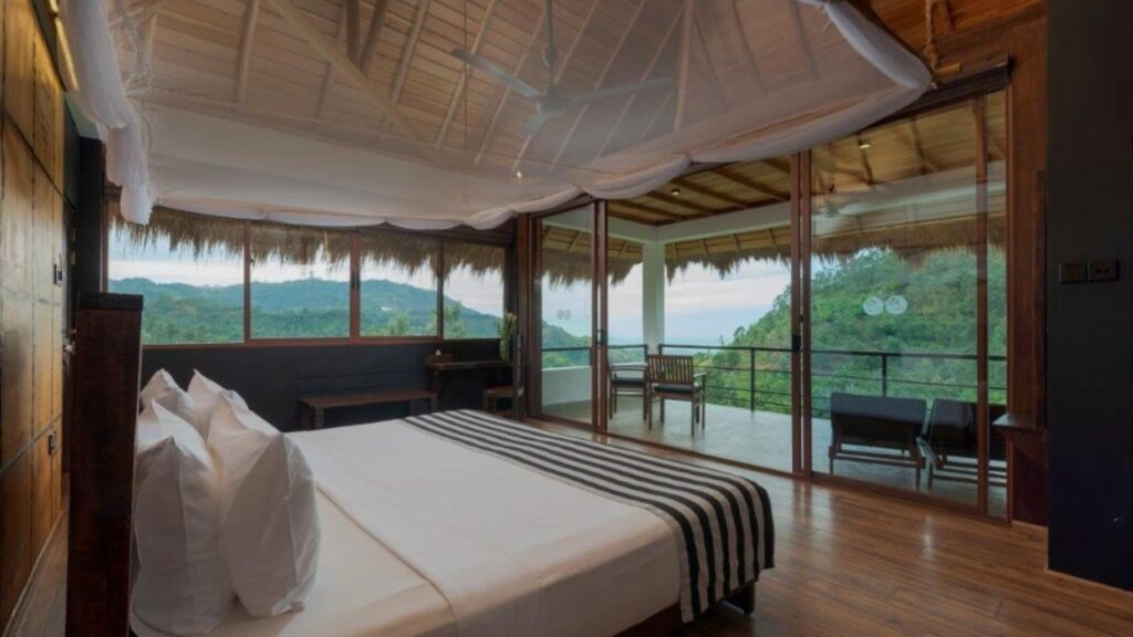 Elegant bedroom at 98 Acres Resort & Spa with a private balcony overlooking Ella’s mountain scenery.