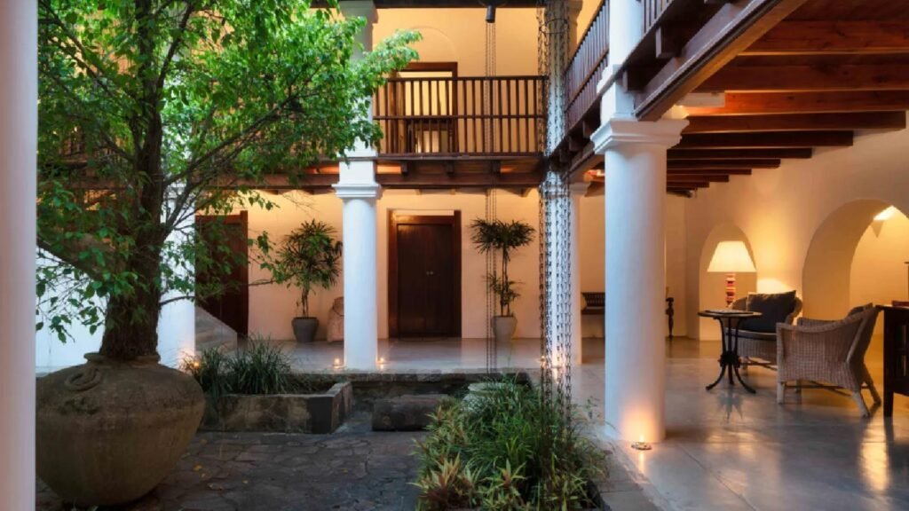 Illuminated colonial-style exterior of Adigar’s Manor in Kandy, surrounded by lush gardens.