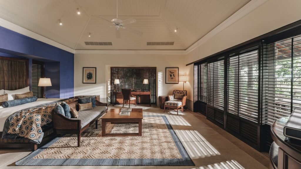 Elegant Cape Weligama room with a king bed, lounge seating, and large shuttered windows.