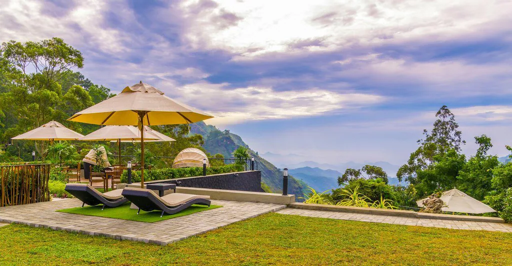 Mountain-view terrace with sun loungers and umbrellas at EKHO Ella, Sri Lanka.