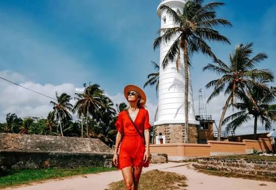 Tourist walking beside the historic lighthouse at Galle Fort, Sri Lanka.