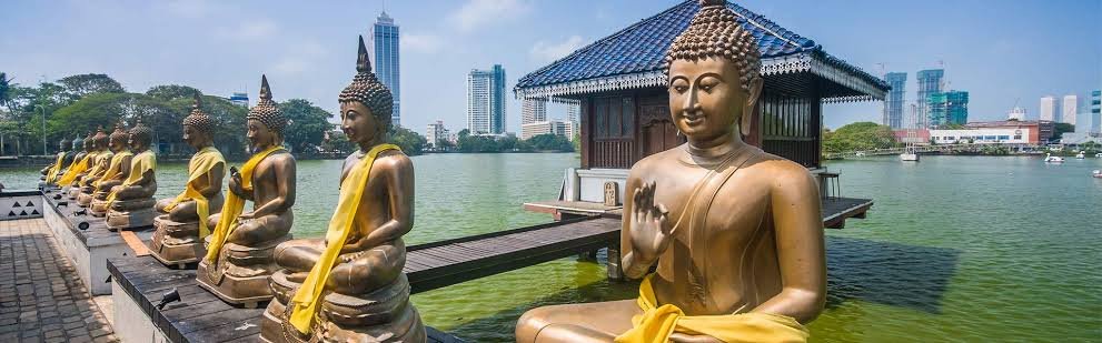 Golden Buddha statues beside Beira Lake at Seema Malaka Temple in Colombo.