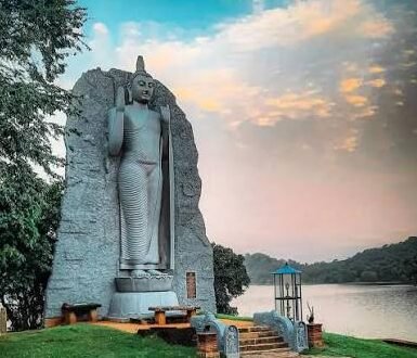Standing Buddha statue overlooking Giritale Reservoir in Sri Lanka.