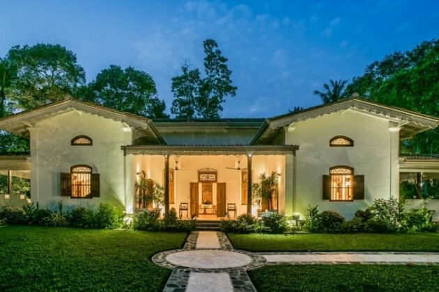 lluminated exterior of JH Villa Thalpe surrounded by a landscaped garden.