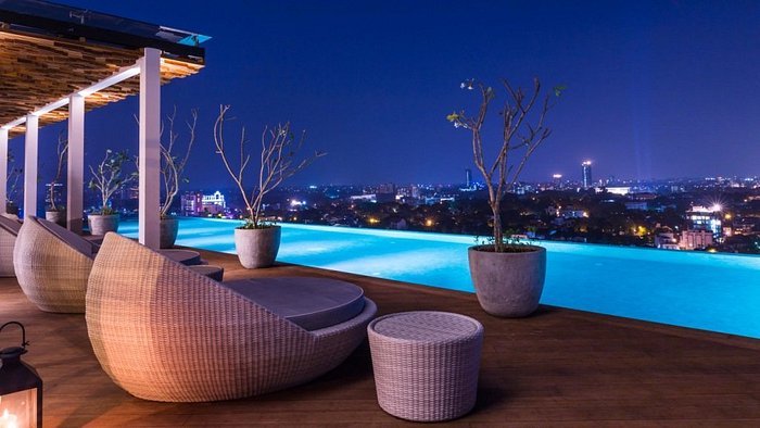 Rooftop infinity pool and lounge overlooking Colombo at night.