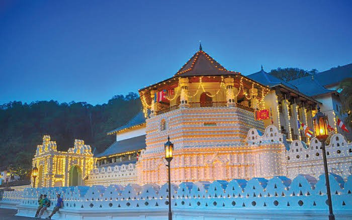 Temple of the Sacred Tooth Relic illuminated at night in Kandy, Sri Lanka.