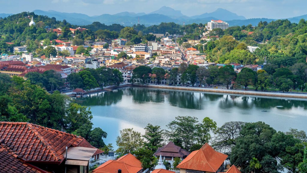 Panoramic view of Kandy city and Kandy Lake surrounded by lush hills.