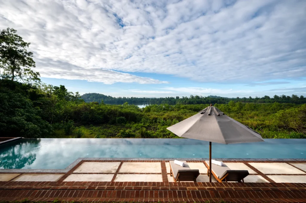 nfinity pool overlooking lush tropical landscapes at Lunuganga Estate Hotel.