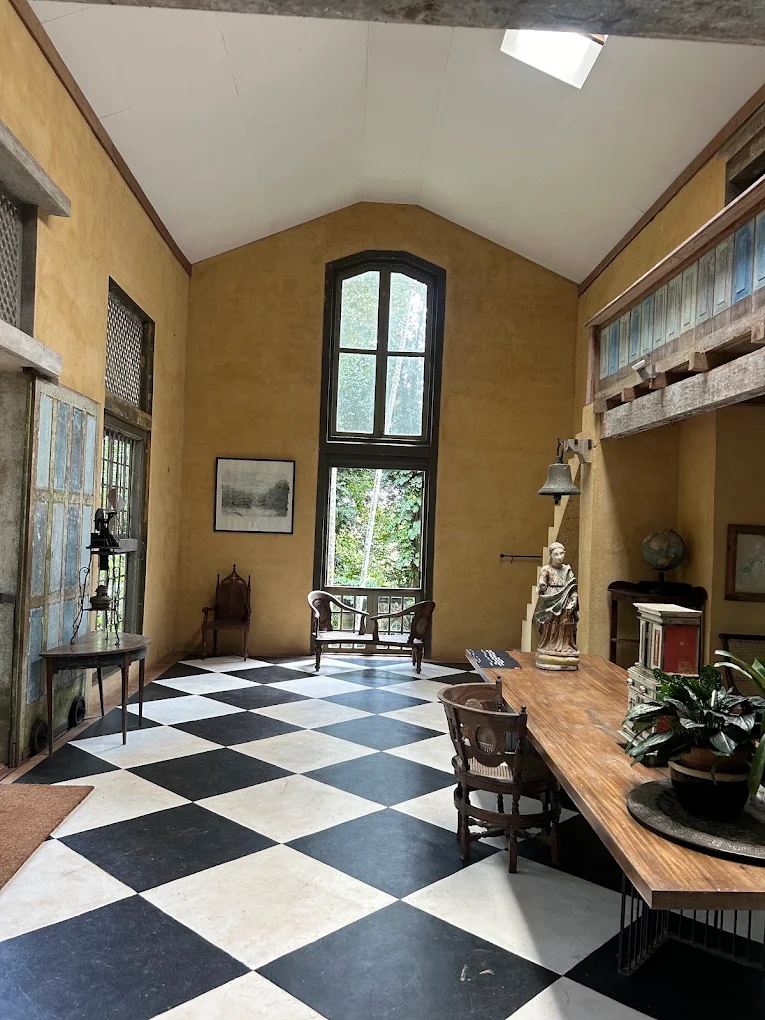Heritage-style interior at Lunuganga Estate Hotel with checkerboard flooring and antique furnishings.