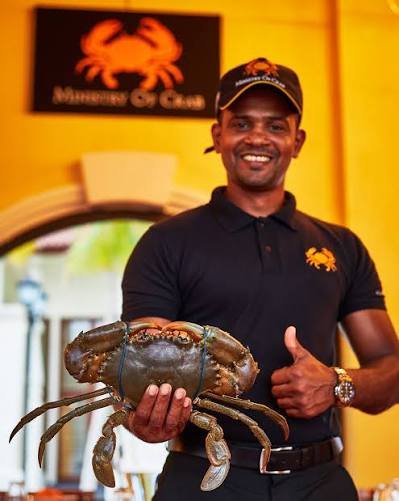 Restaurant staff member holding a large Sri Lankan crab at Ministry of Crab.