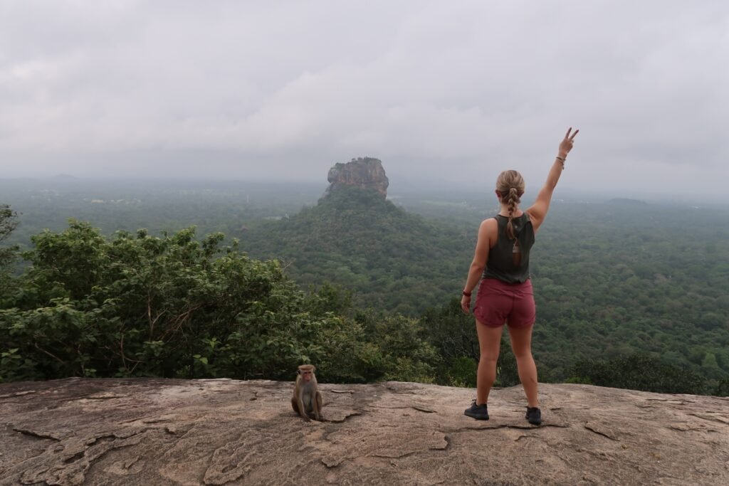 Hiker enjoying panoramic views of Sigiriya from Pidurangala Rock.