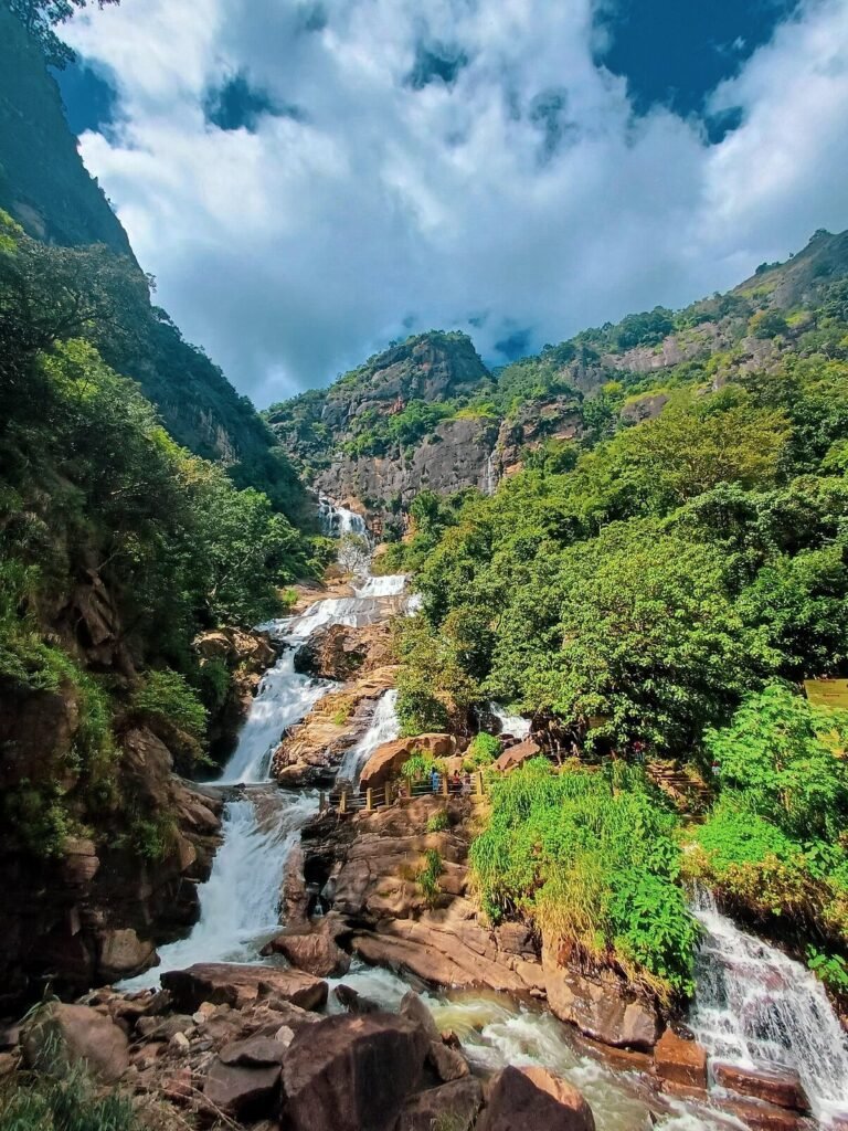 Ravana Falls cascading through lush green mountains near Ella, Sri Lanka.