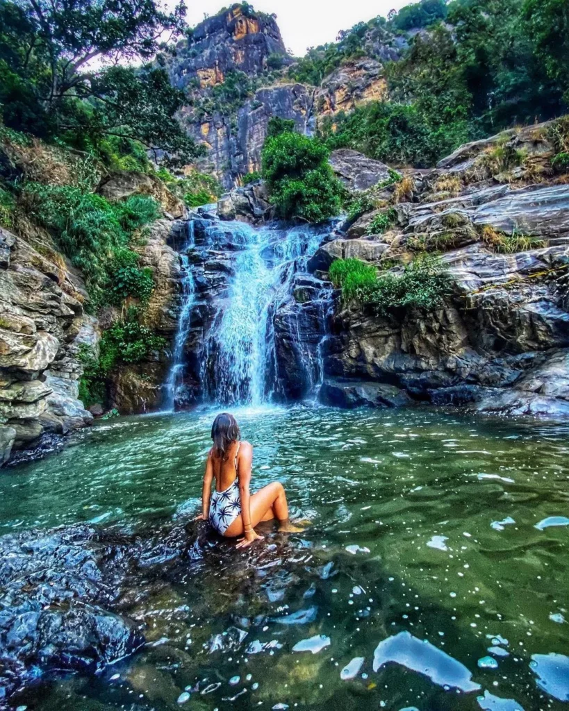 Ravana Falls cascading through lush green mountains near Ella, Sri Lanka.