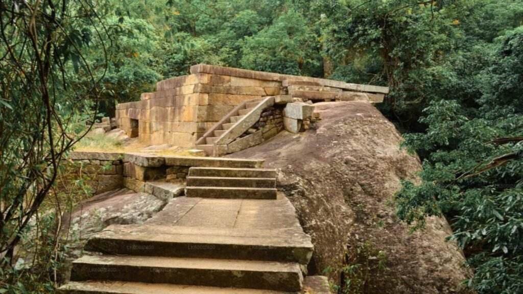 Ancient stone monastery ruins surrounded by dense forest at Ritigala.