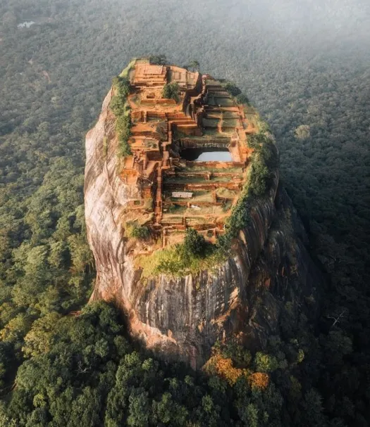 Aerial view of Sigiriya Rock Fortress surrounded by forest in Sri Lanka.