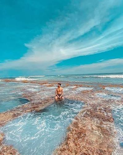 Natural rock pool surrounded by ocean waves at Thalpe Beach, Sri Lanka.