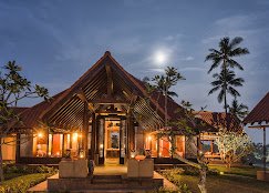 Cape Weligama pavilion glowing at dusk among tropical gardens.