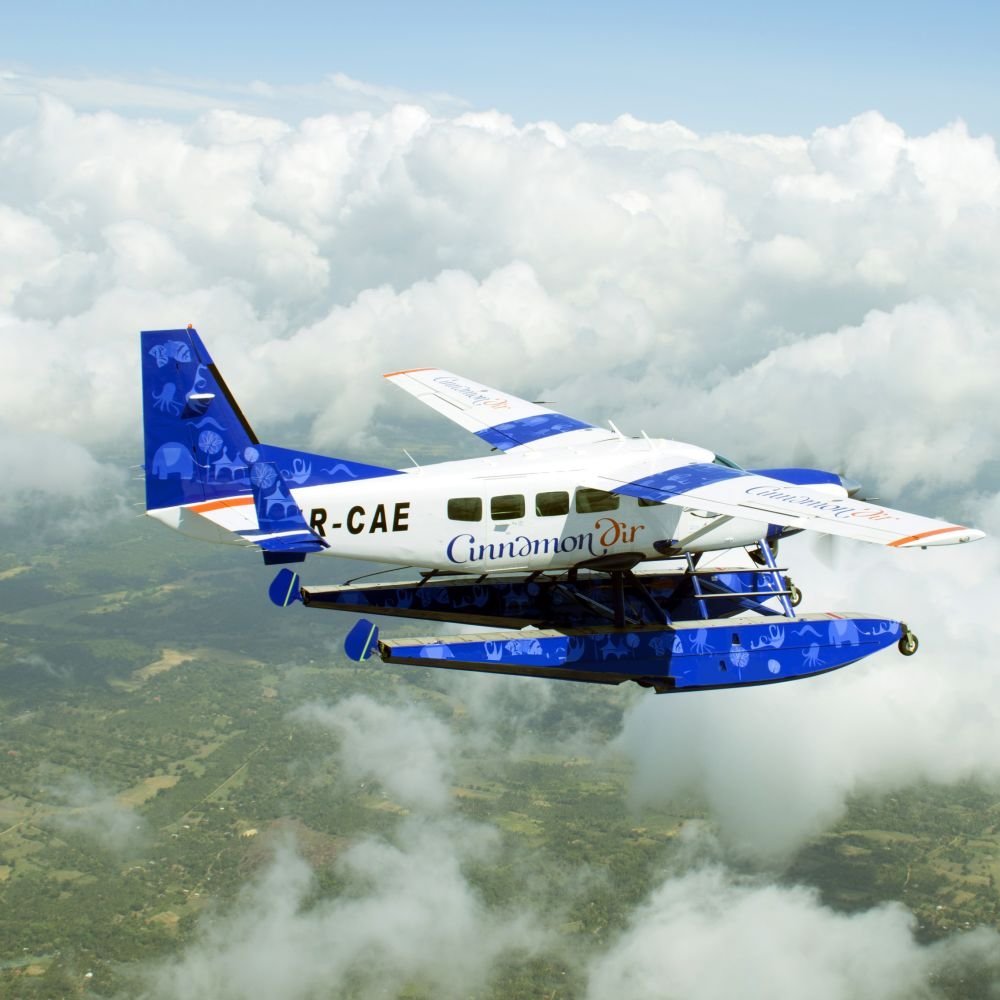 Cinnamon Air seaplane flying above Sri Lanka’s scenic hill country.