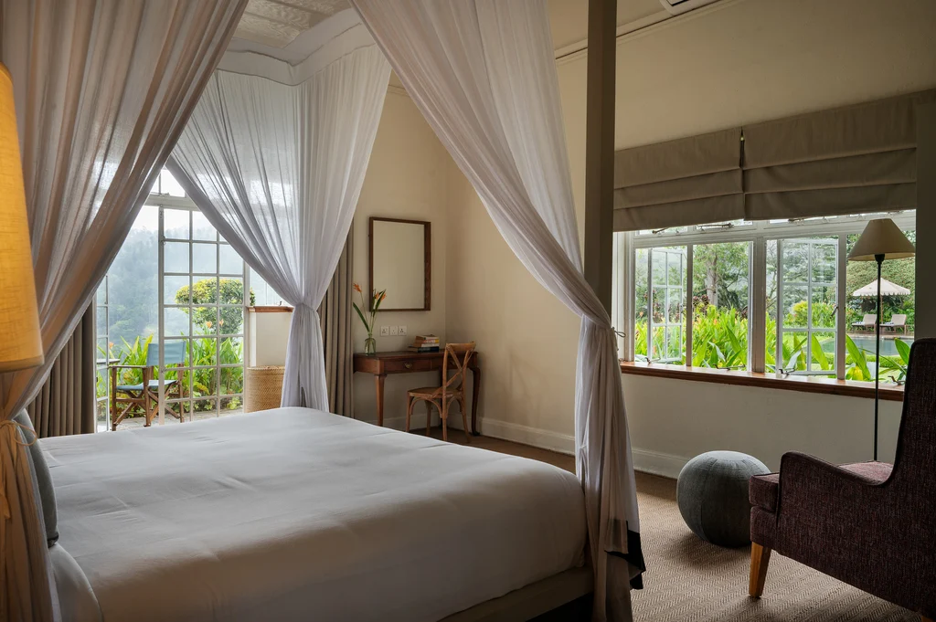 Elegant bedroom with a canopy bed and garden views at Nine Skies.